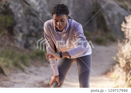 Fitness, nature and woman with time on watch for running speed, progress check and steps monitor on smartwatch or digital technology. Runner, athlete or black woman in mountains training with a timer Fitness, nature and woman with time on watch for running speed, progress check and steps monitor on smartwatch or digital technology. Runner, athlete or black woman in mountains training with a timer 129717998