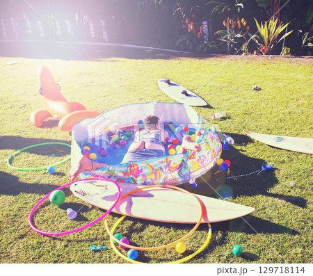 Man, backyard and passed out on grass, drinking and party in summer at with butt open in kids pool. Drunk person, sleeping and lawn with toys, sunshine or hangover on vacation, holiday or celebration 129718114
