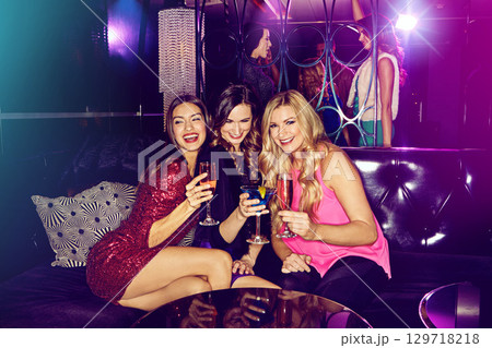 Women friends, sofa and smile in nightclub with drink, glass or cocktail for happiness in night. Woman group, disco party and drinking on club couch for fashion, alcohol or social celebration in dark Women friends, sofa and smile in nightclub with drink, glass or cocktail for happiness in night. Woman group, disco party and drinking on club couch for fashion, alcohol or social celebration in dark 129718218