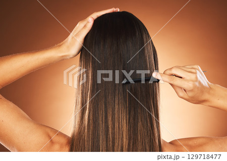 Hair care, salon and back of woman brushing hair, healthy beauty and comb hairstyle against a brown studio background. Wellness, morning routine and model with straight hair treatment for haircare Hair care, salon and back of woman brushing hair, healthy beauty and comb hairstyle against a brown studio background. Wellness, morning routine and model with straight hair treatment for haircare 129718477
