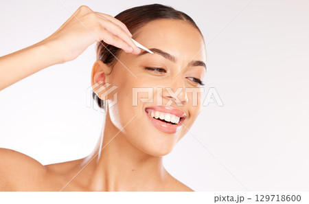 Woman, face or tweezer for eyebrow shape, hair growth management or self care grooming on studio background. Smile, happy or beauty model with hair removal tool for microblading treatment or skincare Woman, face or tweezer for eyebrow shape, hair growth management or self care grooming on studio background. Smile, happy or beauty model with hair removal tool for microblading treatment or skincare 129718600