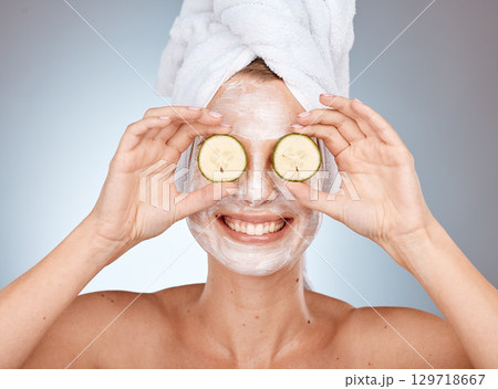 Woman, cucumber and skincare mask for beauty, health and wellness by studio background with smile. Cream, face mask and model with vegetable for facial, cleaning and cosmetics with happiness for skin 129718667