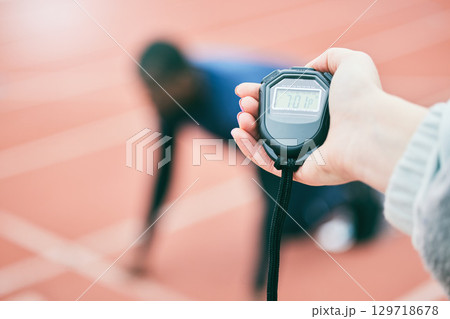 Sports, running and hands with stop watch on race track for exercise, marathon training and fitness. Stadium, workout and athlete team with timer for performance, lap speed and racing competition 129718678