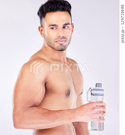 Fit, strong and workout break and water bottle with a man ready to drink water on a grey studio background. Bodybuilder, drinking water and exercise or training break for thirsty hydration Fit, strong and workout break and water bottle with a man ready to drink water on a grey studio background. Bodybuilder, drinking water and exercise or training break for thirsty hydration 129718698