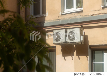 Air conditioners are installed on facade of building. device for comfortable living in hot weather. 129718822