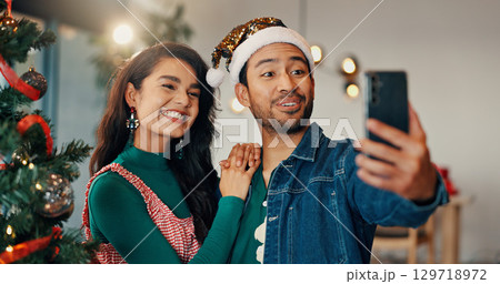 Christmas, selfie and social media with couple in home living room for celebration together. December, holidays or smile of man and woman in apartment for memory, photograph or profile picture Christmas, selfie and social media with couple in home living room for celebration together. December, holidays or smile of man and woman in apartment for memory, photograph or profile picture 129718972