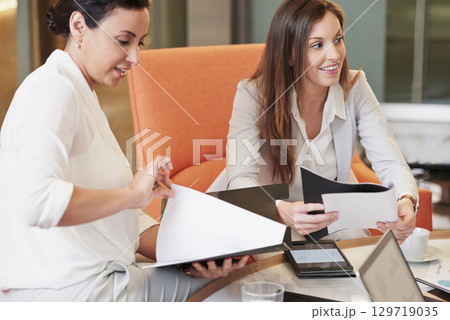 Business people, meeting and documents in team planning, strategy or marketing at the office. Employee women working together on paperwork in teamwork for project plan or ideas at the workplace 129719035