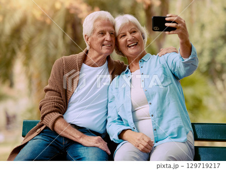 Senior couple, phone selfie and smile on park bench for love, care and social media profile picture of a happy retirement. Old man and woman outdoor together for happiness, support and bonding Senior couple, phone selfie and smile on park bench for love, care and social media profile picture of a happy retirement. Old man and woman outdoor together for happiness, support and bonding 129719217