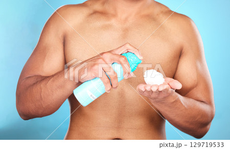 Shaving cream, hand and man with foam for hair removal, grooming or epilation in a studio. Product, skincare and closeup of mousse to shave a facial beard or body hair isolated by a blue background. 129719533