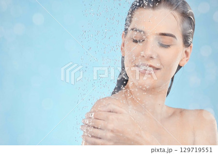 Shower, cleaning and woman with water in studio for spa wellness, body care and self care on blue background. Bathroom, skincare and water drops on girl washing body for hygiene, hydration and health Shower, cleaning and woman with water in studio for spa wellness, body care and self care on blue background. Bathroom, skincare and water drops on girl washing body for hygiene, hydration and health 129719551