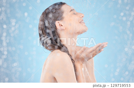 Woman, water splash and showering in skincare grooming, hygiene maintenance and healthcare wellness on blue background. Smile, happy and washing beauty model in wet cleaning for dermatology self care 129719553