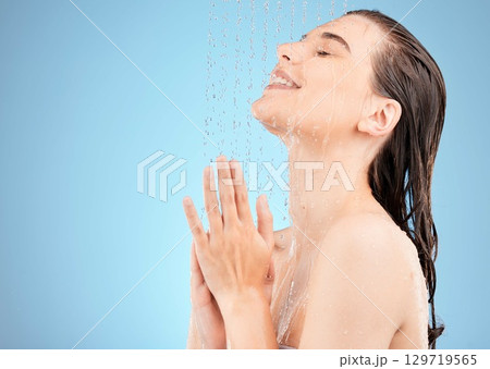 Shower, beauty and woman in studio with water drops for cosmetics, makeup and body cleaning on marketing or advertising space. Happy, young and calm model in bathroom for facial wash and dermatology Shower, beauty and woman in studio with water drops for cosmetics, makeup and body cleaning on marketing or advertising space. Happy, young and calm model in bathroom for facial wash and dermatology 129719565