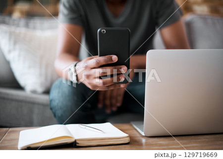 Hands, phone and man with laptop planning on sofa in communication or texting with technology at home. Hand of student chatting on mobile phone, studying or working remote on project in living room Hands, phone and man with laptop planning on sofa in communication or texting with technology at home. Hand of student chatting on mobile phone, studying or working remote on project in living room 129719669