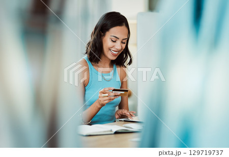 Banking, finance and online shopping with a young woman holding a credit card for retail payment on the internet. Female customer buying, purchasing or spending money on a digital store or shop Banking, finance and online shopping with a young woman holding a credit card for retail payment on the internet. Female customer buying, purchasing or spending money on a digital store or shop 129719737