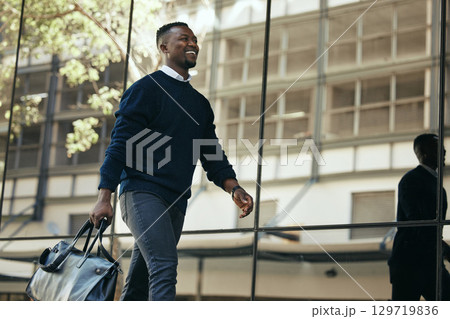 Fashion, travel and corporate employee or businessman traveling and walking out of a building or airport in a city. African American worker or traveler in an urban town with good style going to hotel 129719836