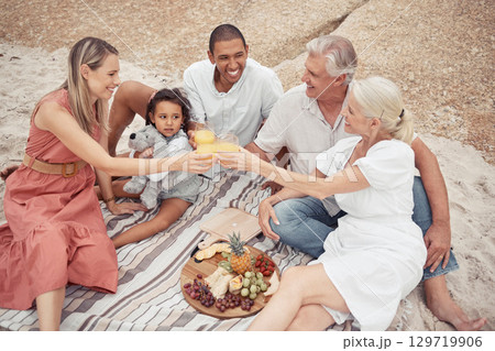 Interracial, family and picnic toast on the beach and smile with some food with snacks. Happy people bonding on travel vacation or holiday in summer with happiness, drink and love with fun together 129719906