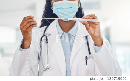 Doctor, covid test and medical healthcare expert working at a hospital, analysis of virus results and face mask for safety at clinic. Hands of African nurse doing professional corona testing 129719992