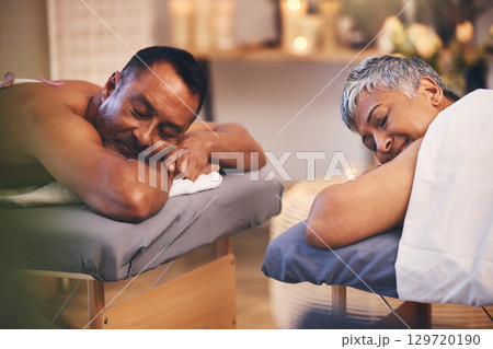 Massage, relax and spa with a senior couple lying on a bed in a health or wellness center for luxury treatment. Health, zen and hospitality with a mature man and woman customer in a salon for therapy 129720190