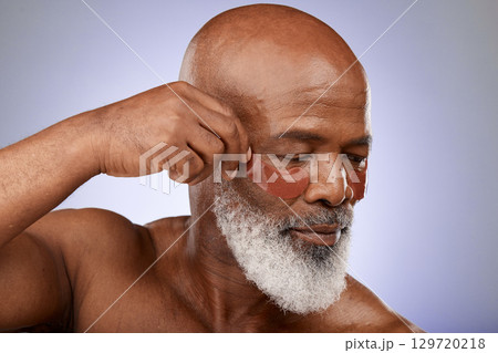 Senior man, eyes mask and face skincare wellness in studio for beauty, cosmetics dermatology or skin treatment. Facial care, natural eyecare product and body care cosmetology in purple background 129720218