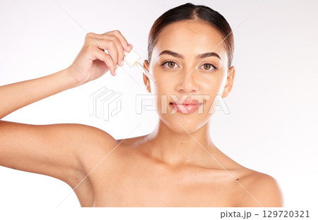Woman, beauty serum and skincare for face in studio, wellness and cosmetics by white backdrop. Happy model, skin and cosmetic portrait with essential oil, aesthetic or hyaluronic acid for self care 129720321