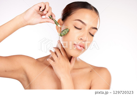 Beauty, skin and face with woman and roller cosmetic tool, skincare and cosmetics with glow and shine against white studio background. Facial massage, self care and wellness with cosmetology mockup. Beauty, skin and face with woman and roller cosmetic tool, skincare and cosmetics with glow and shine against white studio background. Facial massage, self care and wellness with cosmetology mockup. 129720323