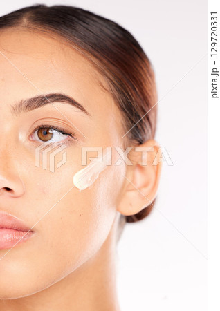 Skincare cream, half face and woman with beauty wellness, spa cosmetics and thinking against white studio background. Luxury product, facial moisturiser and model with sunscreen or dermatology lotion 129720331