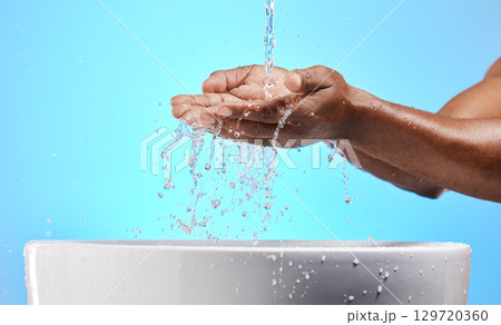 Cleaning, washing and hands with water in studio on blue background for wellness, hydration and virus safety. Skincare, health and black person washing hands for germ protection, hygiene and bacteria 129720360