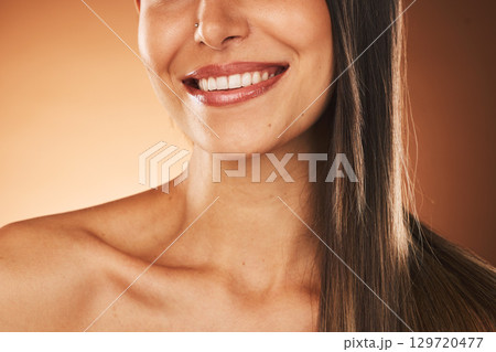 Happy, smile and woman with hair care, skincare and beauty cosmetic treatment in a studio. Happiness, health and girl model with a wellness facial skin routine isolated by a gradient brown background 129720477