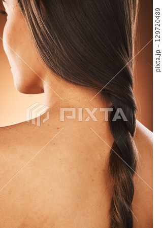 Hair, beauty and back of woman with braid for hair care, hair salon and luxury in orange background studio. Wellness, fashion and girl with healthy, natural and long hairstyle from keratin treatment Hair, beauty and back of woman with braid for hair care, hair salon and luxury in orange background studio. Wellness, fashion and girl with healthy, natural and long hairstyle from keratin treatment 129720489