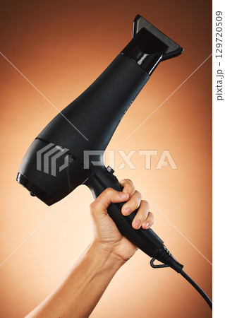 Hair, hand with hair dryer and hair care with beauty and cosmetic advertising against orange studio background. Salon, hairdressing and hairstyle tool or appliance with cosmetics marketing. 129720509