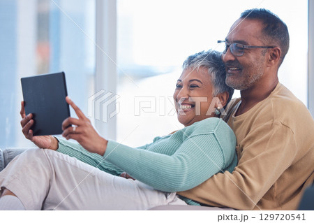 Movie, communication and senior couple with a tablet, streaming film and show on the living room sofa of their house. Website, social media and elderly man and woman with comedy and app on tech 129720541