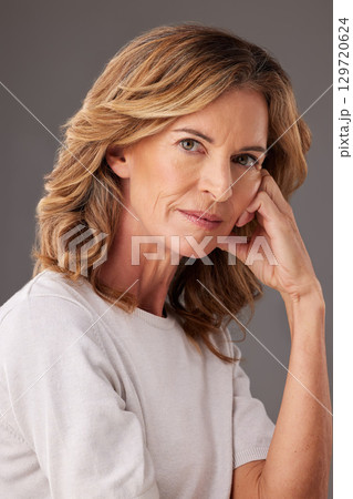 Face, beauty and skincare with senior woman serious about health, wellness and self love against studio background. Portrait of female model posing for cosmetics, antiaging and dermatology treatment. Face, beauty and skincare with senior woman serious about health, wellness and self love against studio background. Portrait of female model posing for cosmetics, antiaging and dermatology treatment. 129720624