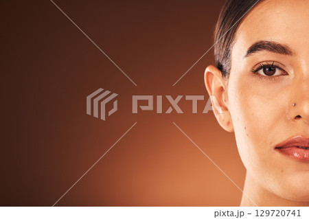 Skincare, half face portrait and woman with a wellness, health and natural facial routine in a studio with mockup space. Cosmetic, beauty and model with face treatment isolated by a brown background. Skincare, half face portrait and woman with a wellness, health and natural facial routine in a studio with mockup space. Cosmetic, beauty and model with face treatment isolated by a brown background. 129720741