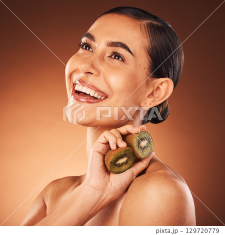 Beauty, skincare and woman in studio with kiwi fruit or natural face cleaning product for grooming routine. Mockup, wellness and happy girl model smiles with organic facial dermatology cosmetics 129720779