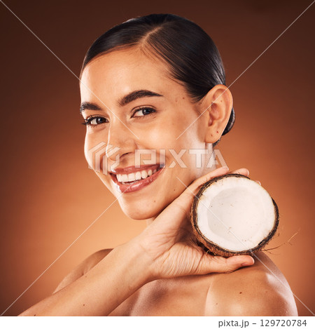 Coconut, woman and beauty, skincare and portrait, cosmetics and healthy food for diet, aesthetics and body nutrition benefits on studio background. Happy young model, coconut oil and natural wellness Coconut, woman and beauty, skincare and portrait, cosmetics and healthy food for diet, aesthetics and body nutrition benefits on studio background. Happy young model, coconut oil and natural wellness 129720784