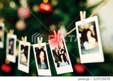 Christmas, family and photo hanging for decoration on peg line for festival, tradition and vacation at home. Photography, holiday celebration and canvas pictures of people to decorate Christmas tree 129720876