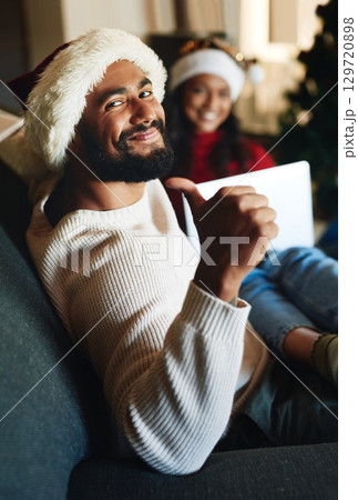 Portrait, home and man with thumbs up on Christmas in celebration of a Christian holiday with wife at home. Love, smile and happy person enjoys a special family day on sofa in winter in New Zealand 129720898