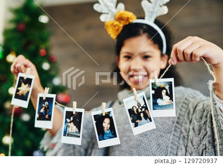 Girl portrait, polaroid and christmas celebration, happy smile and memories, photograph and decoration in home. Child, picture and string for xmas, celebrate and festive holiday, happiness and kid 129720937