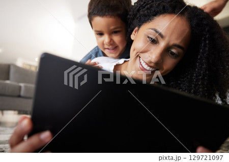 Love, mother with son on back and on floor with tablet, reading and learning together for quality time. Happy, mama and boy on ground, device and bonding on break, weekend and enjoy online videos 129721097