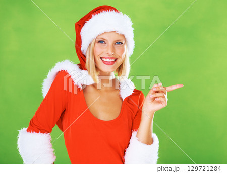 Christmas, woman and costume while pointing, hand and advertising, marketing or branding space. Portrait, model and festive holiday, celebration or portrait in green studio background for xmas mockup Christmas, woman and costume while pointing, hand and advertising, marketing or branding space. Portrait, model and festive holiday, celebration or portrait in green studio background for xmas mockup 129721284