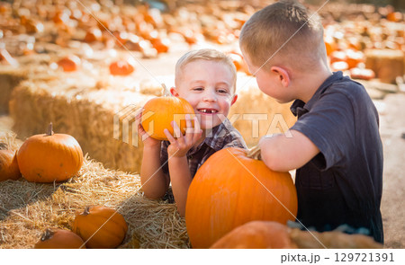Two Boys Having Fun at the Pumpkin Patch on a Sunny Fall Day. 129721391