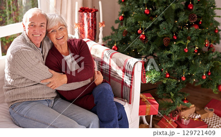 Christmas, senior couple and couch for happiness, festive season or relax together at home. Xmas, love and elderly woman with mature man, smile or bonding for love, content and on sofa in living room 129721409
