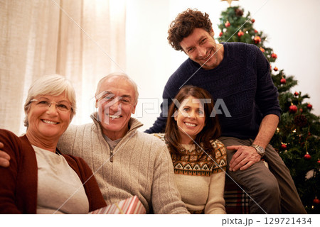 Christmas, family and visit with a man, woman and senior parents together in the living room of a home. Portrait, happy and bonding with a mother, father and in laws celebrating the festive season Christmas, family and visit with a man, woman and senior parents together in the living room of a home. Portrait, happy and bonding with a mother, father and in laws celebrating the festive season 129721434