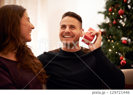 Couple, Christmas and love with guess gift box for surprise, happiness and holiday excitement. Happy, marriage and present for partner guessing what is inside with cheerful smile in home. Couple, Christmas and love with guess gift box for surprise, happiness and holiday excitement. Happy, marriage and present for partner guessing what is inside with cheerful smile in home. 129721446