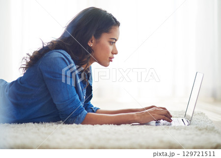 Floor, laptop and relax with a woman blogger or freelance worker doing remote work from home while lying. Computer, email and technology with a young female online working on her carpet in a house 129721511