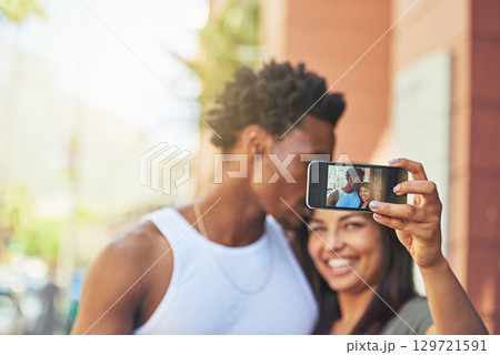 Phone, happy or black couple with selfie kiss for love, happiness or bonding in city, street or town. Photo, smile or man and woman with 5g smartphone for social media, media app or blog upload 129721591