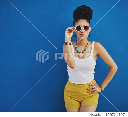Fashion, summer and black woman with sunglasses on blue background wall in city on weekend. Freedom, beauty and girl enjoy holiday, travel and vacation in urban town with trendy clothes and cosmetics Fashion, summer and black woman with sunglasses on blue background wall in city on weekend. Freedom, beauty and girl enjoy holiday, travel and vacation in urban town with trendy clothes and cosmetics 129721597