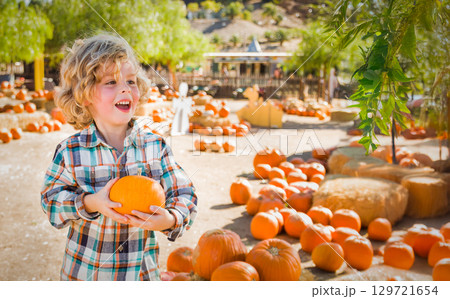 Cute Young Boy Having Fun at the Pumpkin Patch on a Sunny Fall Day. Cute Young Boy Having Fun at the Pumpkin Patch on a Sunny Fall Day. 129721654