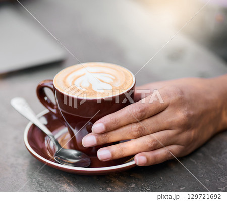 Latte cup, hands on table with art for customer services, restaurant creativity and hospitality industry with inspiration. Cafe shop with person hand holding espresso, cappuccino or coffee drink 129721692