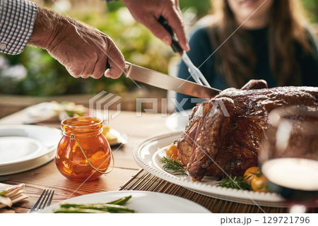 Food, hands and turkey with family at a table in celebration of thanksgiving, tradition and lunch meal on a patio. Chicken, hand and man carving meat to share with friends at christmas party outdoor Food, hands and turkey with family at a table in celebration of thanksgiving, tradition and lunch meal on a patio. Chicken, hand and man carving meat to share with friends at christmas party outdoor 129721796